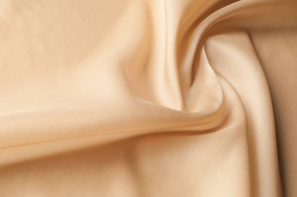 istock Texture background of fabric. Beige fabric. Silk fabric wallpaper texture background pattern in sepia pastel yellow cream beige tint: Lovely natural silk textured textile 1051126542