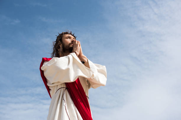 istock low angle view of Jesus praying against blue sky 1051128028