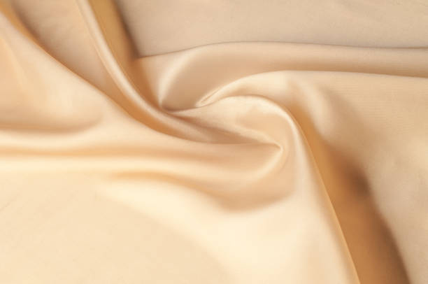 istock Texture background of fabric. Beige fabric. Silk fabric wallpaper texture background pattern in sepia pastel yellow cream beige tint: Lovely natural silk textured textile 1051135850