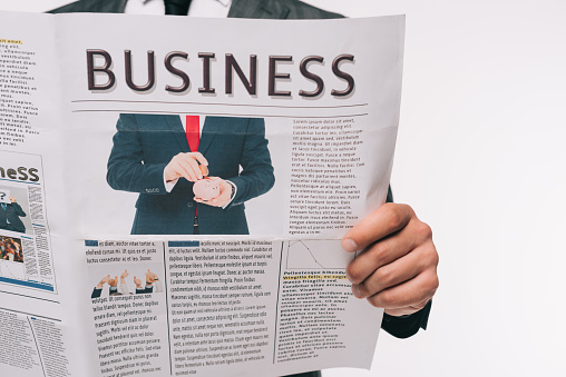 cropped image of businessman reading business newspaper isolated on white