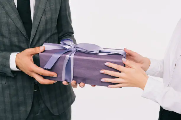 cropped image of businesswoman presenting gift to coworker isolated on white