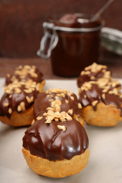 istock Eclairs with chocolate and nuts on wooden background 1051139068