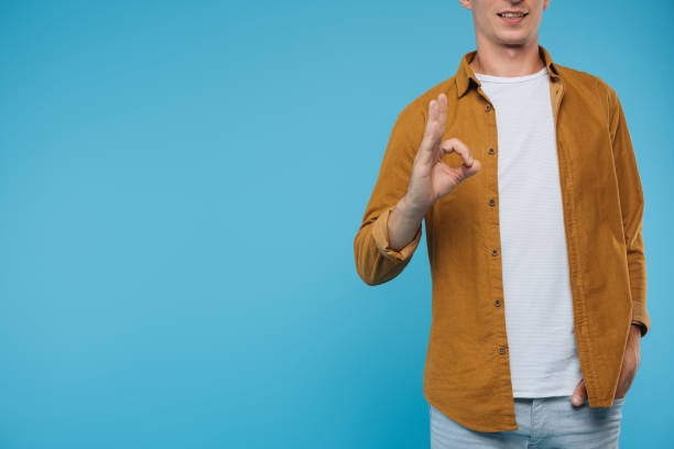 istock cropped image of man showing okay gesture isolated on blue 1051139270