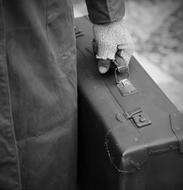 бедный путешественник с изношенным кожаным чемоданом с черно-белым эффектом - 1930 стоковые фото и изображения