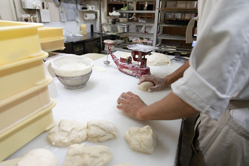 Pasta maker machine, woman's hands prepare fresh pasta sheets for tagliatelle, ravioli or lasagna.