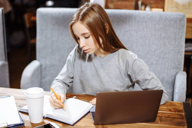 istock Attractive girl student preparing for examination learning new information. Talented writer pondering on new movie on laptop computer creating article review. 1051144074