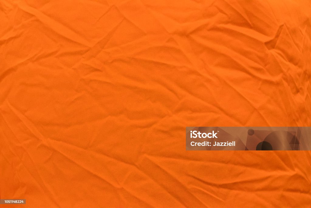 Ярко-оранжевая ткань со светлыми складками крупным планом - Стоковые фото Абстрактный роялти-фри