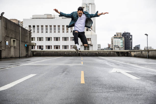 hombre asiático en exploración urbana en los techos de la ciudad - men on roof fotografías e imágenes de stock