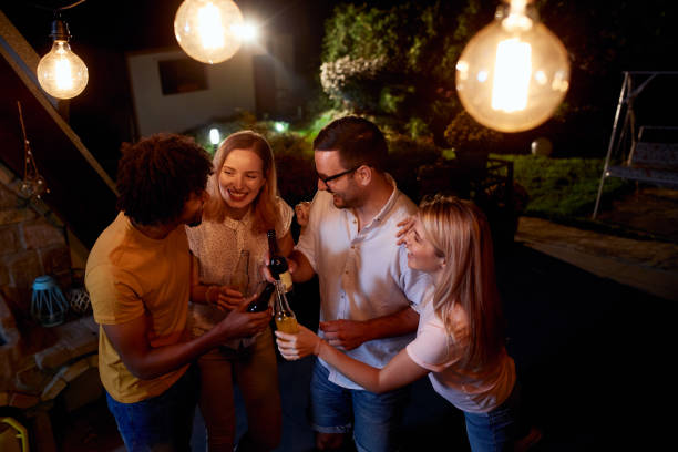 istock Joyful friends having a drinking party during the night on a terrace. 1051151292