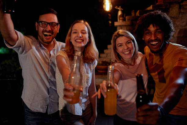 istock Joyful friends having a drinking party during the night on a terrace. 1051151756