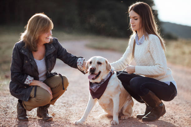 istock Mother and daughter petting dog 1051152274