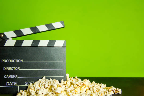 istock Popcorn and clapperboard on green screen background for cinema background 1051152306