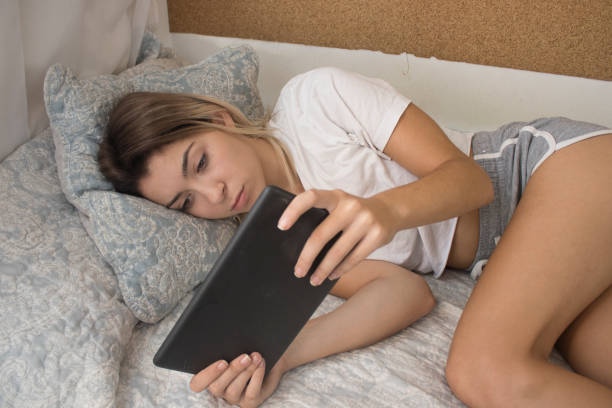 istock Young girl in bed with tablet 1051152726