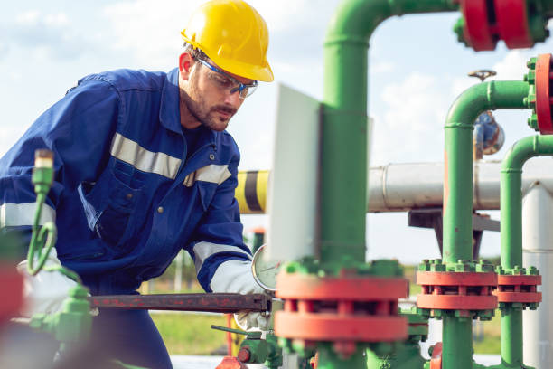 istock Worker adjusting gauge at oil refinery 1051160172
