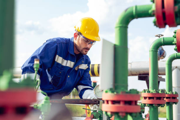 istock Worker adjusting gauge at oil refinery 1051160268
