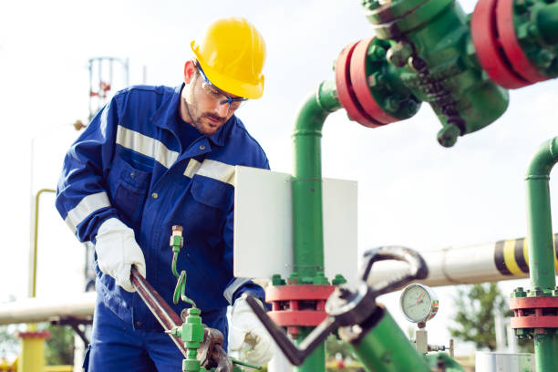 istock Worker adjusting gauge at oil refinery 1051160392
