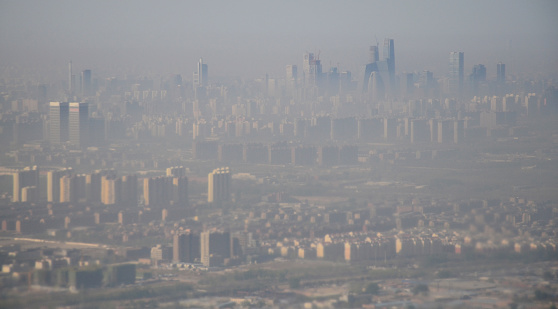 A heavy layer of smog hangs gloomily over Beijing, as seen from the window of an airplane.