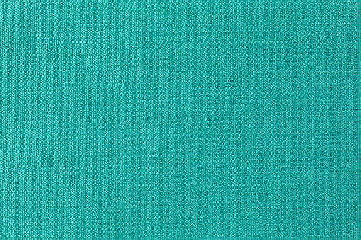 Close view of old green fabric with a close weave.