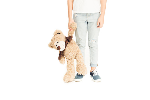 cropped image of child holding teddy bear isolated on white
