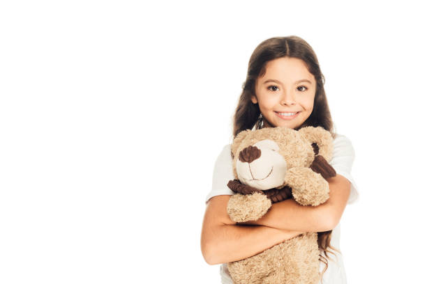 Lovely child model posing with teddy bear FOR YOU at pink background, pensive look at camera. Kid cover girl 5 year old together love toy, studio shot. Children, childhood concept. Copy ad text space