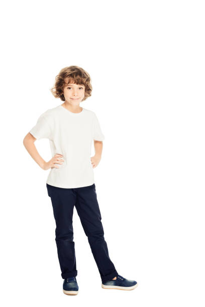 istock smiling adorable boy standing with hands akimbo and looking at camera isolated on white 1051171500
