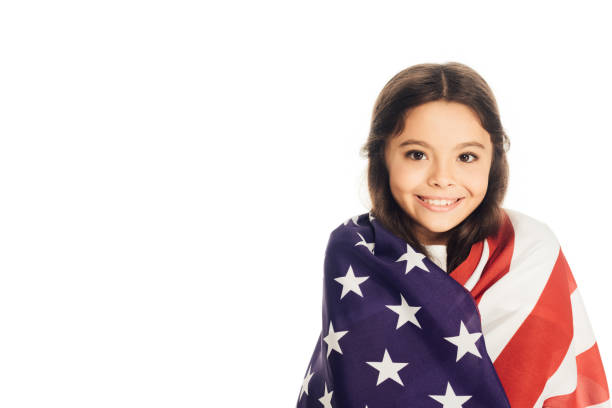 istock smiling adorable kid wrapped in american flag looking at camera isolated on white 1051171546