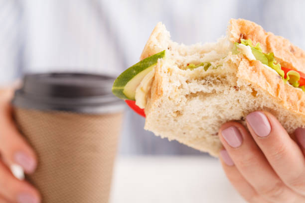 istock Bitten cheese and lettuce sandwich in hand, whole sandwich 1051176924