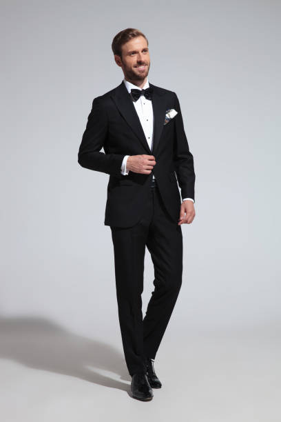 istock happy elegant man standing on grey background 1051180008