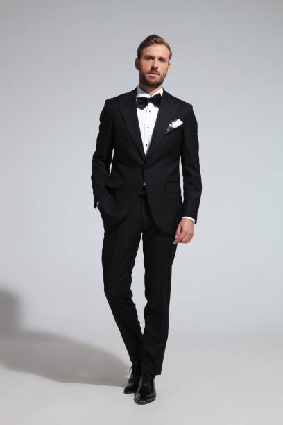 istock arrogant elegant man in tuxedo standing with hand in pocket 1051180126