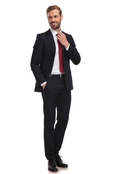 istock relaxed businessman fixes his red tie and looks to side 1051180456