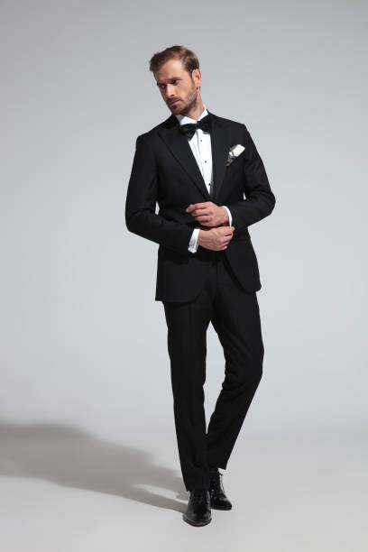 istock young elegant man in tuxedo fixing his cufflinks 1051180802