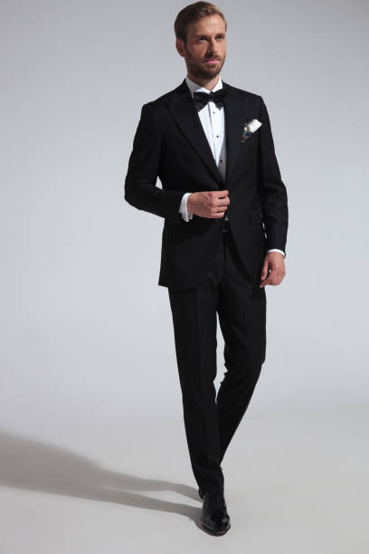 istock side view of a man in tuxedo holding his button 1051181396