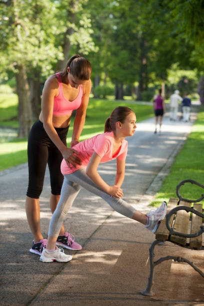 istock Mother and daughter stretching on park bench 1051186260