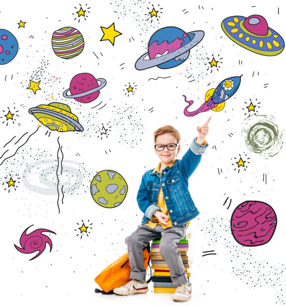 istock smiling schoolboy pointing up while sitting on pile of books with backpack, isolated on white with fantasy universe, planets and spaceships 1051187324