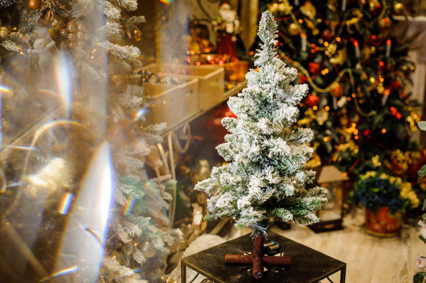 istock Little artificial Christmas tree on a stand decorated with artificial snow in a shop 1051190206