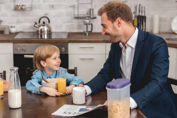 istock father and son laughing together at kitchen during breakfast 1051190716