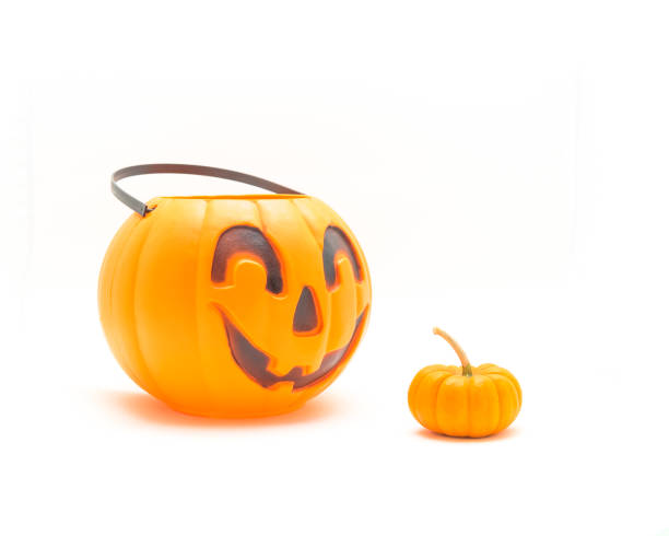 istock Studio shot plastic Halloween pumpkin pail and mini pumpkin isolated on white 1051201962