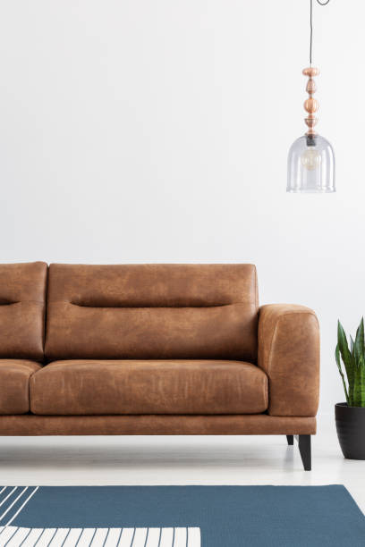 istock Copy space above big brown leather sofa in modern apartment, vertical view, real photo 1051202924