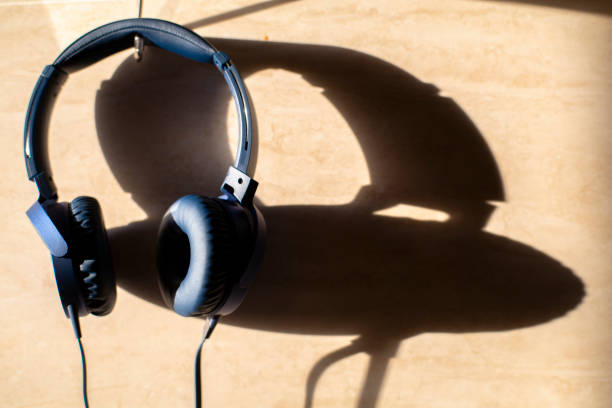 istock headphones hanging on wall with shadow by sunlight 1051207230