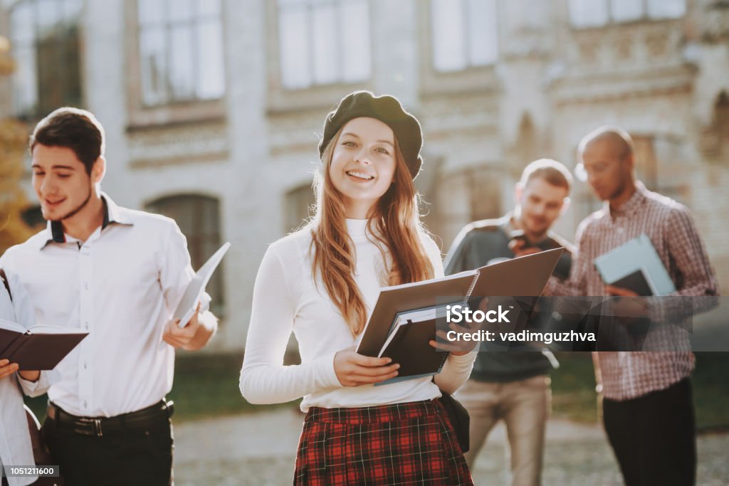 Campus. Books. Redhead. Coffee. Happy. Good Mood. Campus. Books. Redhead. Coffee. Happy. Good Mood. University. Knowledge. Courtyard. Architecture. Happiness. Girl. Intelligence. Diploma. Celebration. Man. Friends. Standing in University. Students. Beret Stock Photo