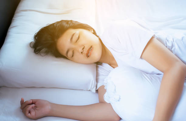 Women sleeping on the bed and grinding teeth,Female tiredness and stress Female sleeping on the bed and grinding teeth,Female tiredness and stress grinding stock pictures, royalty-free photos & images