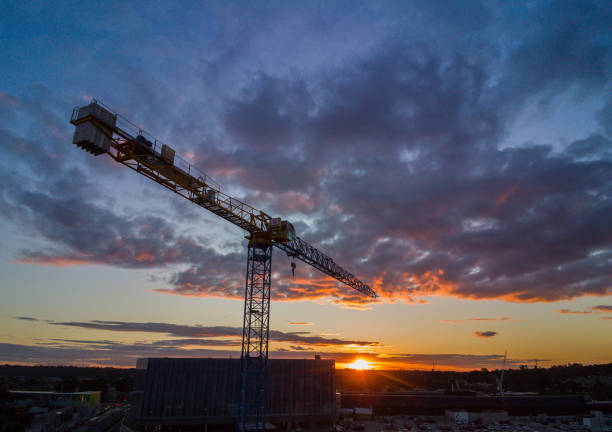 Silhouette crane construction tower at sunset stock photo