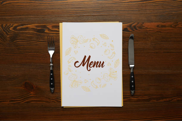 istock top view of Menu with fork and knife on wooden table 1051235764