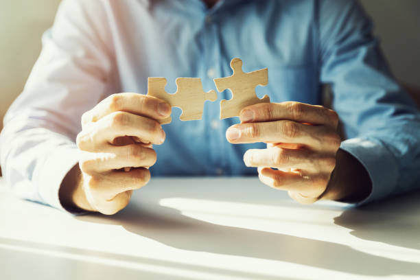 istock business solutions - businessman connecting jigsaw puzzle 1051235854