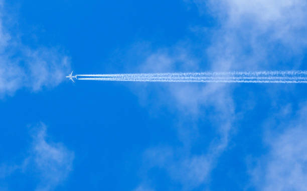 istock A jet flies across a blue cloudy sky leaving vapour trails 1051236302