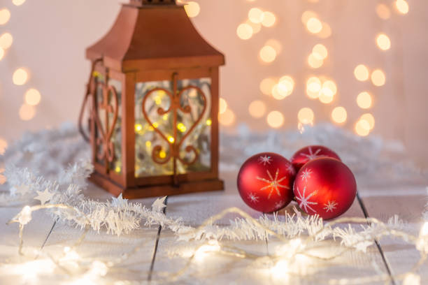 istock Red Christmas balls and red lantern on a white wooden table 1051237264