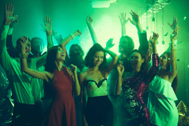 istock Welcome to the best night party! Sequins fall on careless, carefree, ecstatic, positivity, happiness, emotion, excited, people dancing in party club with neon lights 1051239448