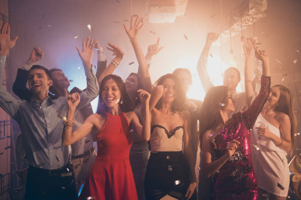 istock Lets dance all night! Silver sequins fall from the ceiling on couples, lovers, friends, crowd people, moving in the party mood club make big hollywood smile 1051239764