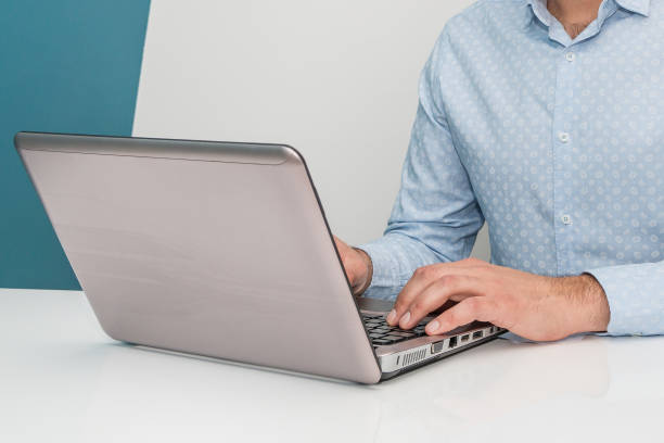 istock Male hands typing on laptop keyboard. Man working at home office and using lap top or notebook. Close up. 1051241128
