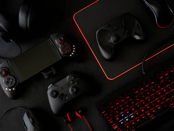 istock gamer workspace concept, top view a gaming gear, mouse, keyboard, joystick, headset, mobile joystick, in ear headphone and mouse pad on black table background. 1051243570